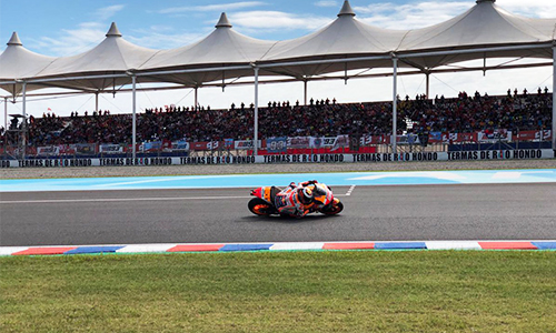 Foto dentro del autódromo, donde se ve a Mad Marques en su Moto Gp1 con la tribuna techada de fondo.